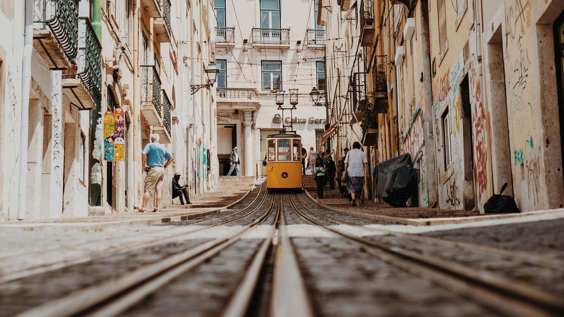 Ascensor da Bica parado no topo com pessoas a andar no passeio